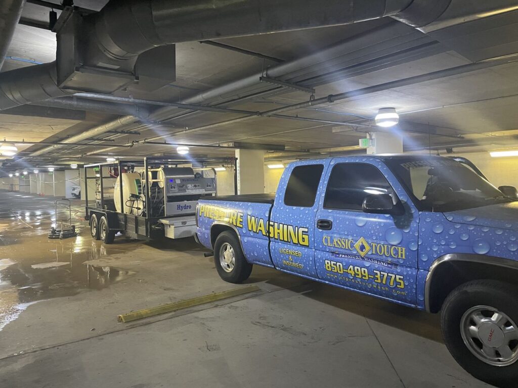 Commercial pressure washing team cleaning a multi-level parking garage floor with industrial-grade hot water machines in Florida.”